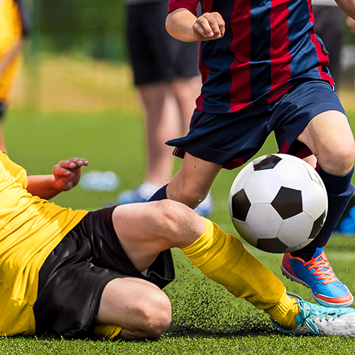 kids playing soccer, one fallen down