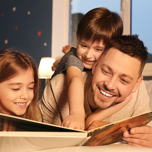Dad reading a book to his two children