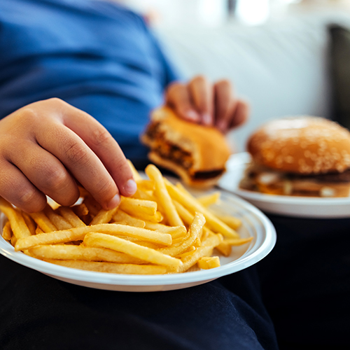 Teen eating burger and chips