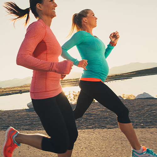 Pregnant athlete running with friend